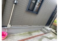 住宅の外壁に設置したEV充電コンセントと、外壁に沿った配管